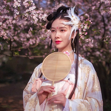 粉色桃花拂面帶團(tuán)扇女生頭像，唯美古風(fēng)真人頭